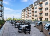 Thumbnail 6 of 53 - an outdoor patio with tables and chairs and an apartment building in the background